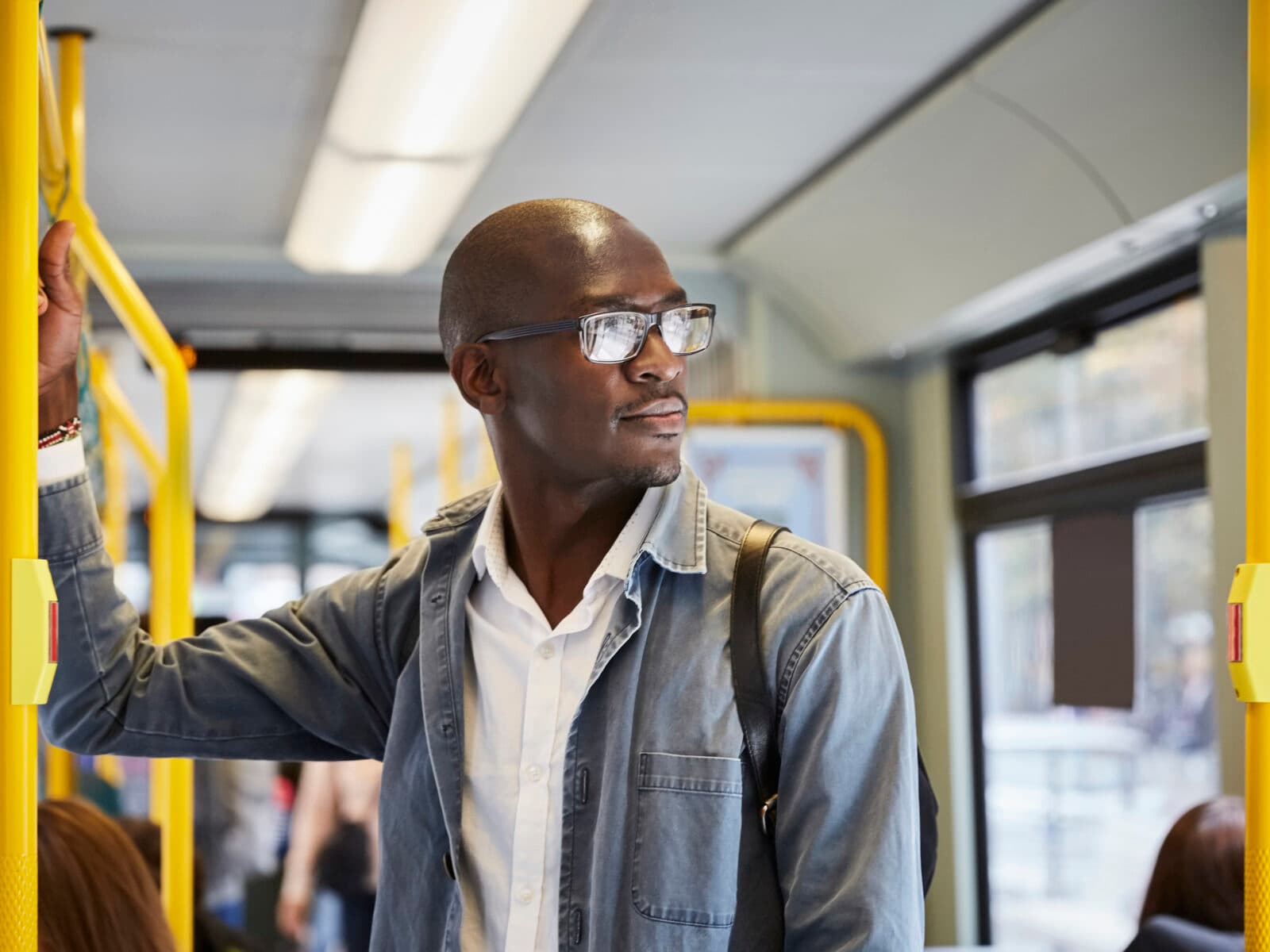 35-39 år, afroamerikansk etnicitet, buss, affärsman, linbana, stad, stadsliv, färgbild, pendlare, helt skallig, självförtroende, dag, jeansjacka, europa, glasögon, framifrån, innehav, horisontell, tillfälliga människor , landfordon, tittar bort, mitten av vuxen, mitten av vuxna män, transportsätt, en person, passagerare, fotografi, kollektivtrafik, skandinavien, selektiv inriktning, stående, stockholm, sverige, spårväg, transport, resa, fordonsinredning, midja upp , pendling, urban