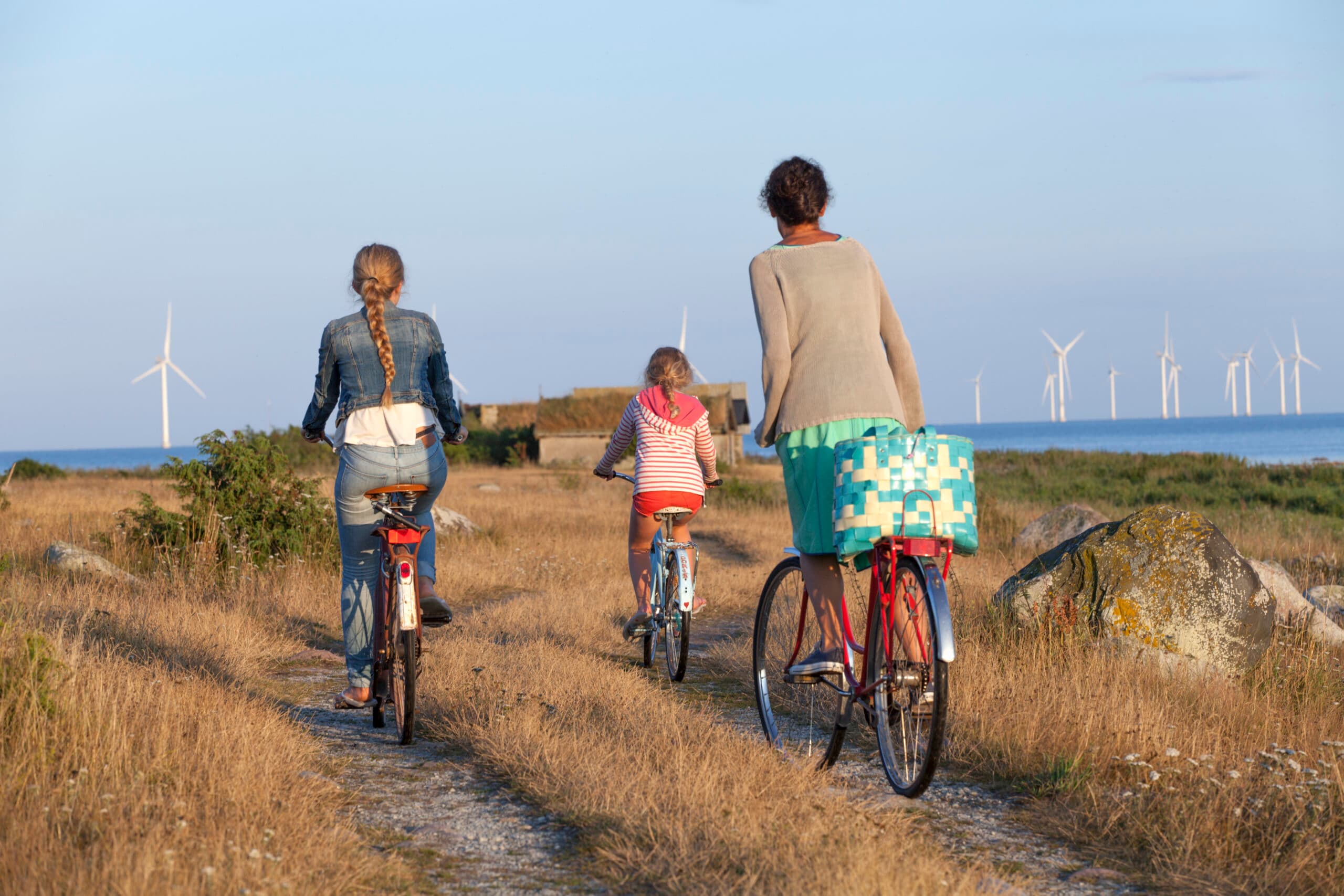 mamma, cykel, klar himmel, kvinnor, tonårsflicka, årstider, tre personer, ljus, kust, familj, energi, cykel, dotter, ensamstående förälder, bakifrån, dagtid, utomhus, syskon, fritid, asfalterad väg, förnybar energi, full längd, Öland, friluftsliv, synvinkel, semester, sommarlov, vindkraftverk.