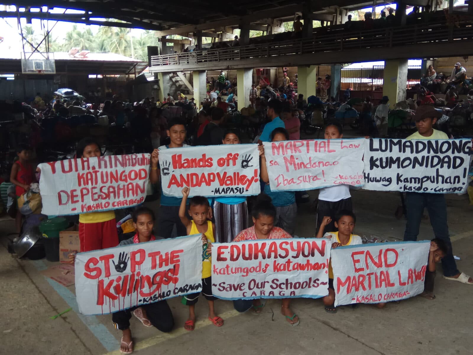 Lärare och elever vid ALCADEV byskola i Mindanao, Filippinerna, protesterar mot den senaste vågen av ...