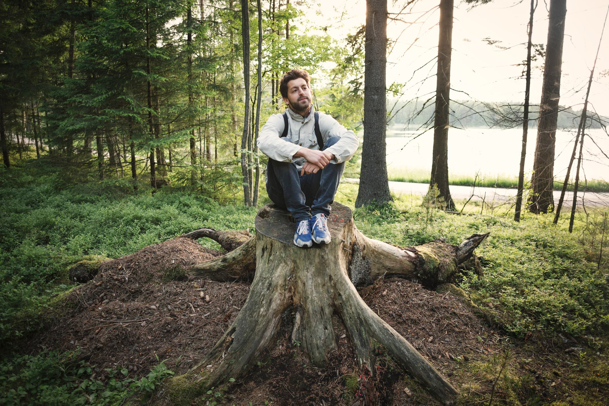 Man som sitter på stubbe i skogen. Bilden har använts till Uppdrag skog.